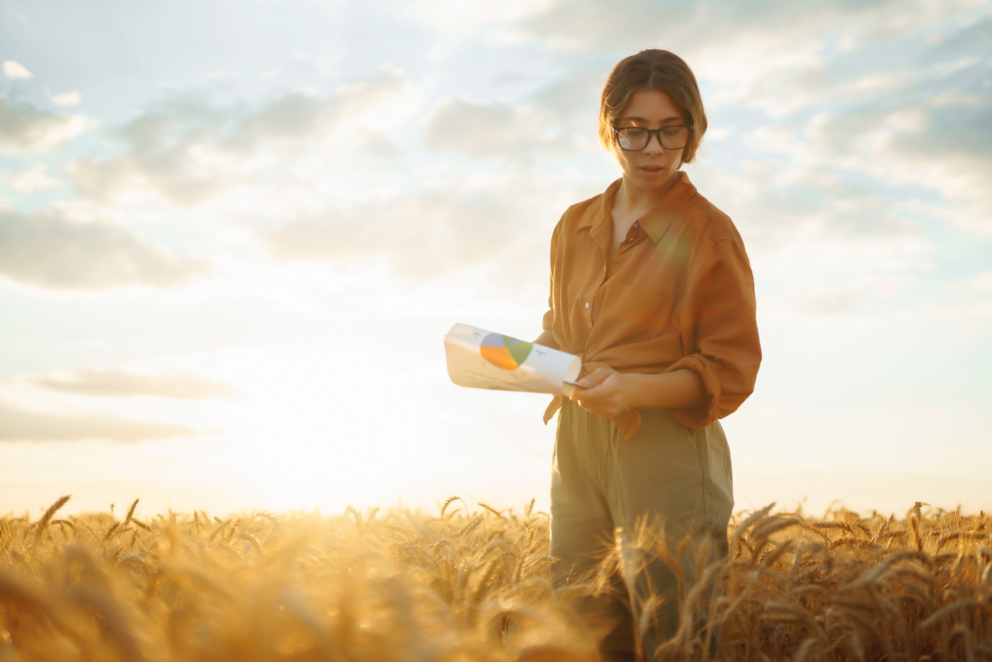 Farmer woman in a wheat field checking crop. Harvesting, gardening or ecology concept. Smart farming
